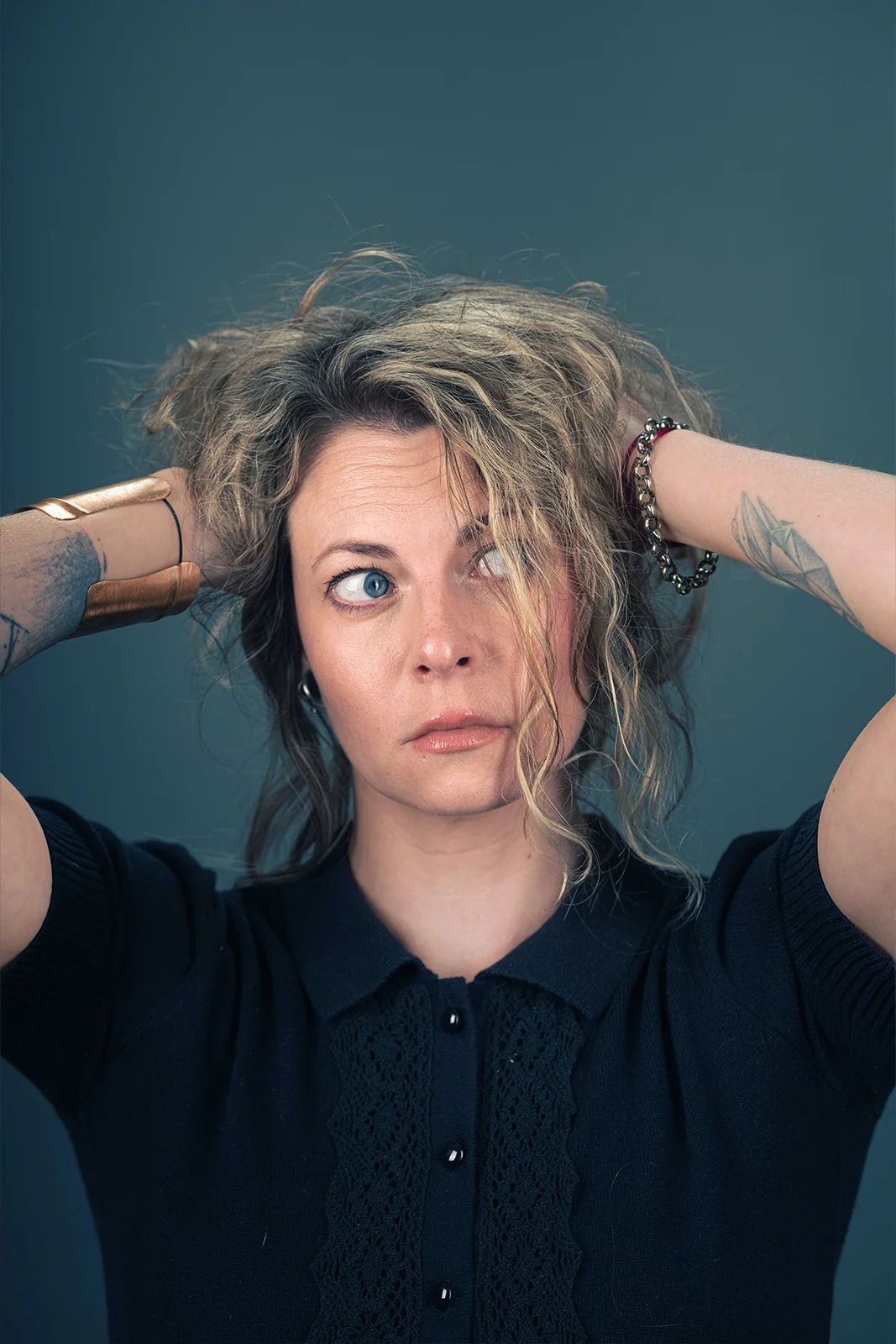 Portrait d'une femme aux cheveux courts, les mains dans les cheveux dans un studio à Nancy